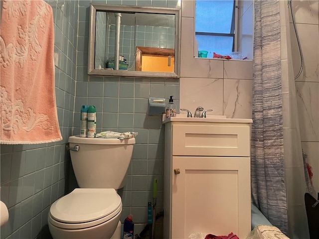 bathroom with toilet, tile walls, and curtained shower