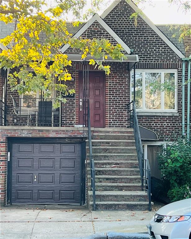 view of front of property featuring an attached garage, concrete driveway, and brick siding