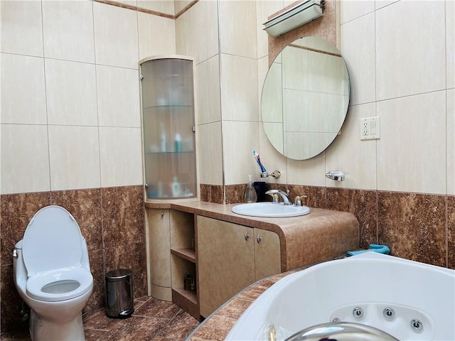 bathroom with a whirlpool tub, toilet, a sink, and tile walls