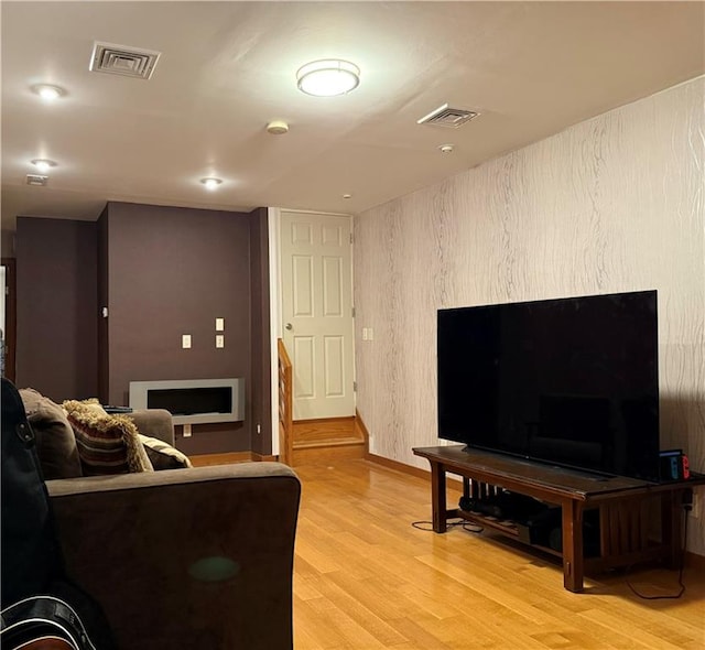 living area featuring baseboards, visible vents, and light wood-style floors