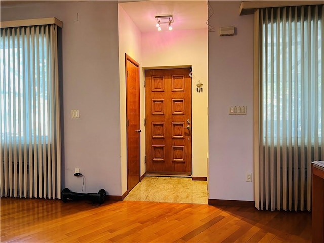 foyer with rail lighting and light hardwood / wood-style flooring