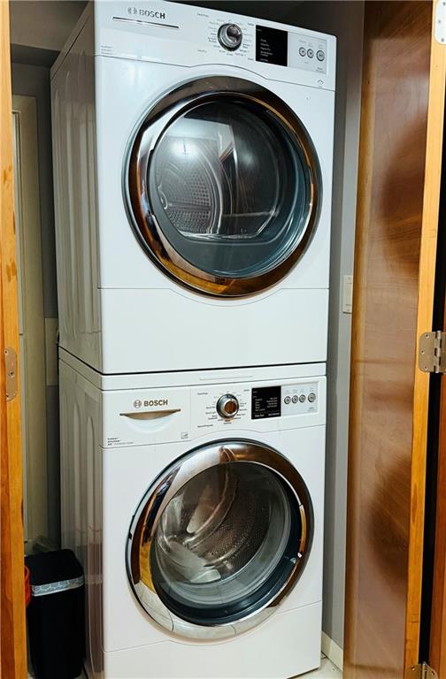 washroom featuring stacked washer and clothes dryer