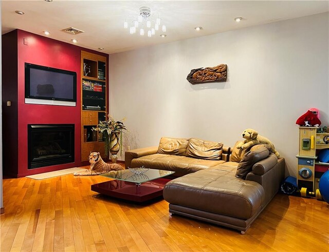 living room featuring an inviting chandelier and wood-type flooring