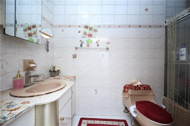 full bathroom with toilet, vanity, tile walls, and tiled shower / bath