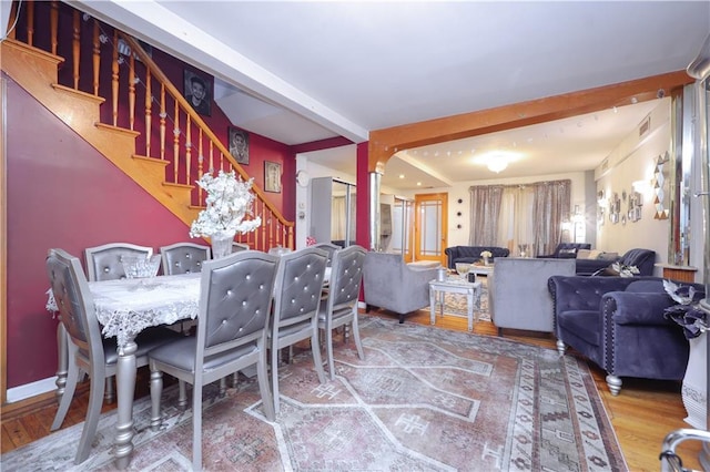 dining space with beamed ceiling and hardwood / wood-style flooring