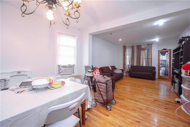 dining area featuring a notable chandelier, wood-type flooring, and cooling unit