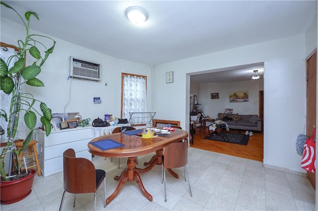 dining space with light hardwood / wood-style flooring and an AC wall unit