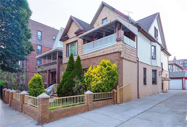 exterior space with cooling unit, a balcony, an outbuilding, and a garage