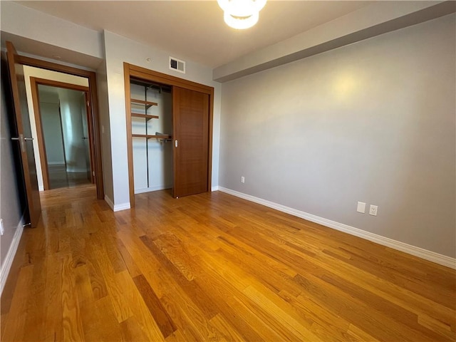 unfurnished bedroom featuring light hardwood / wood-style flooring and a closet