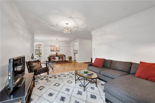 living room featuring a notable chandelier and light wood-type flooring