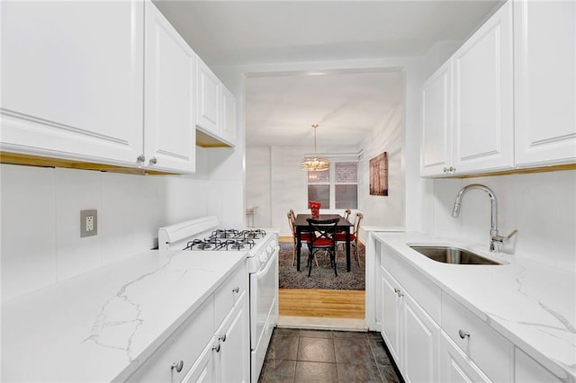 9411 Shore Rd Unit 1A, Brooklyn, NY 11209 - kitchen featuring white gas range oven, a chandelier, white cabinets, and light stone countertops