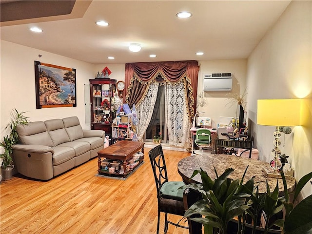 living room featuring a wall mounted air conditioner and hardwood / wood-style flooring