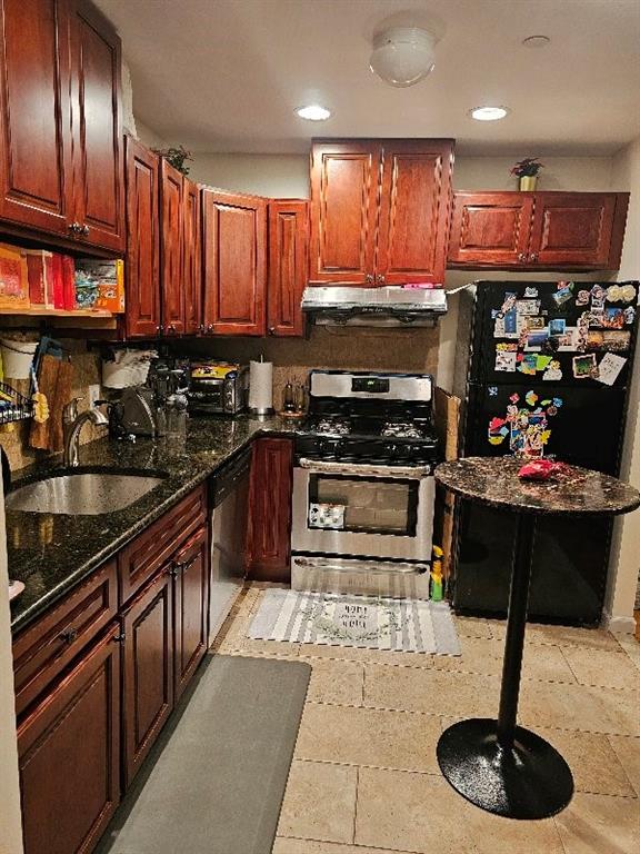 kitchen with dark stone countertops, sink, and stainless steel appliances