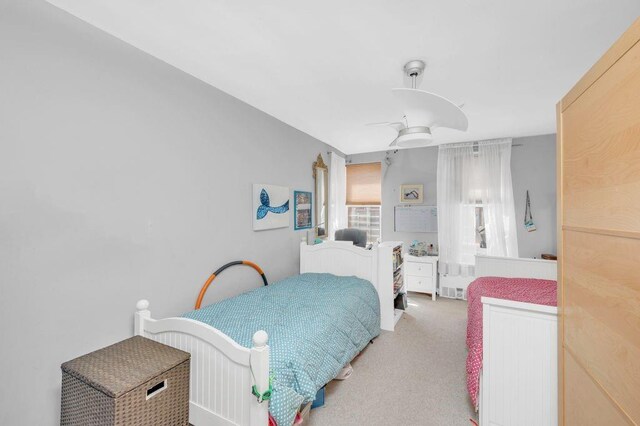 bedroom featuring light carpet and ceiling fan