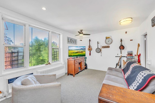 carpeted living room featuring ceiling fan and radiator