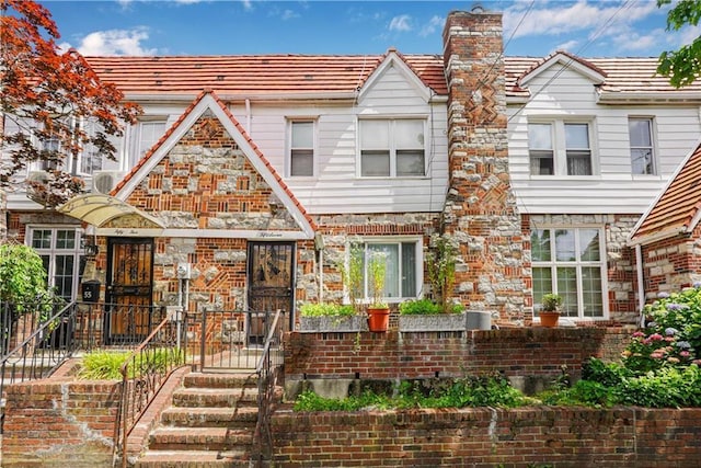 multi unit property with brick siding and a chimney