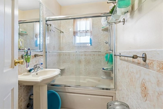 bathroom featuring shower / bath combination with glass door and tile walls