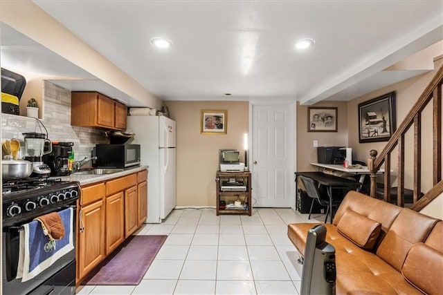 kitchen featuring tasteful backsplash, sink, white fridge, light tile patterned floors, and black gas stove