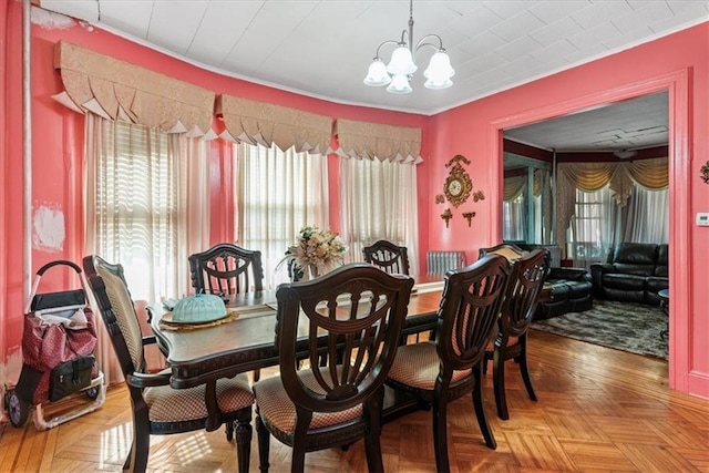 dining space featuring crown molding, parquet flooring, and a notable chandelier