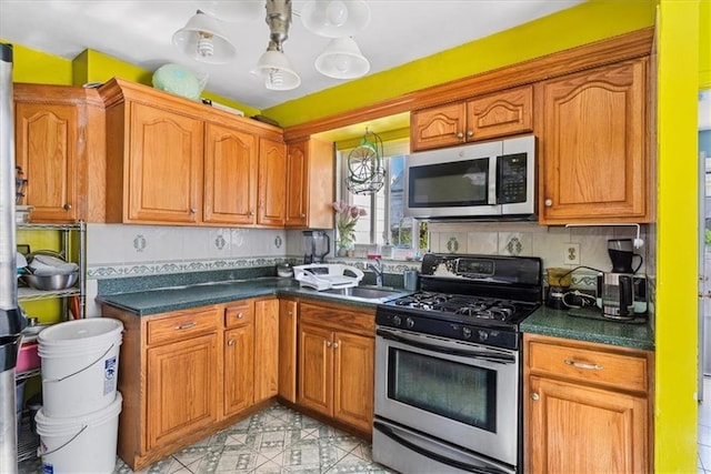 kitchen featuring appliances with stainless steel finishes, sink, and decorative backsplash