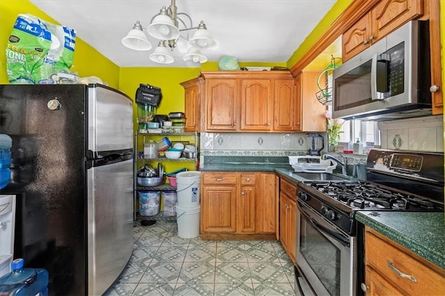 kitchen featuring stainless steel appliances, sink, a chandelier, and decorative backsplash