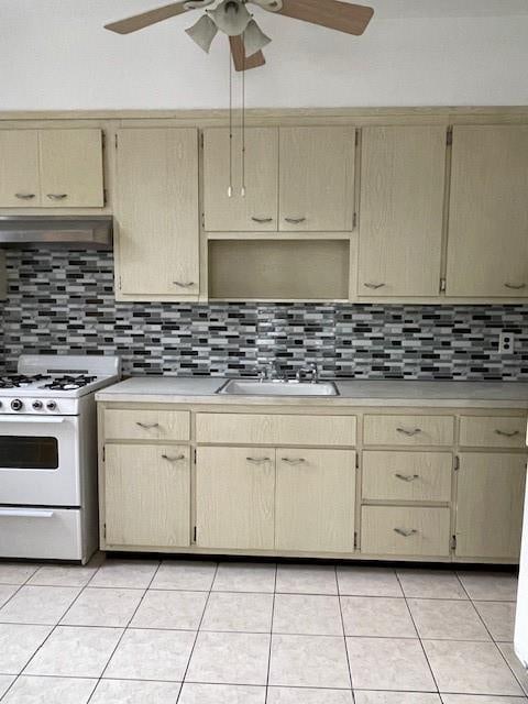 kitchen with light countertops, tasteful backsplash, gas range gas stove, and under cabinet range hood