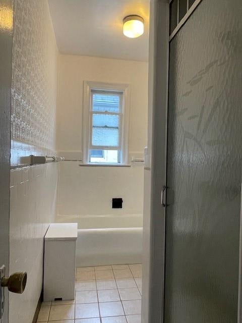 bathroom with a tub to relax in, a stall shower, and tile patterned flooring