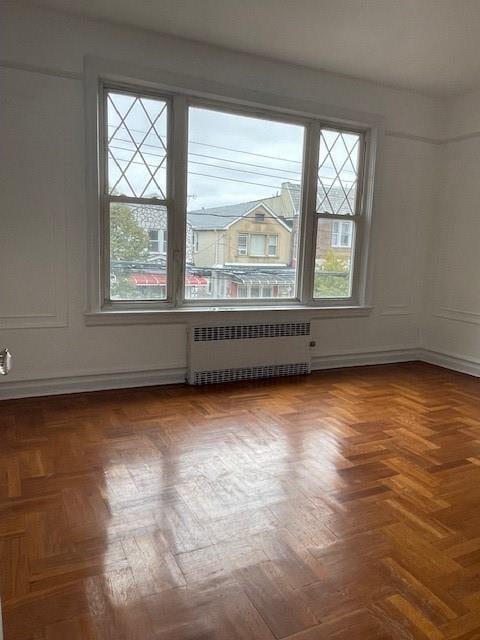 unfurnished room featuring radiator