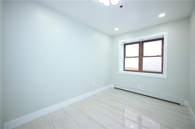 empty room with light wood finished floors, recessed lighting, baseboards, and a baseboard radiator