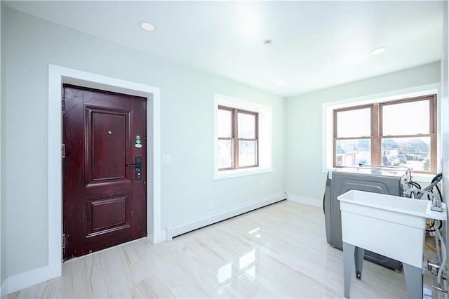 clothes washing area with laundry area, recessed lighting, baseboards, and a baseboard radiator