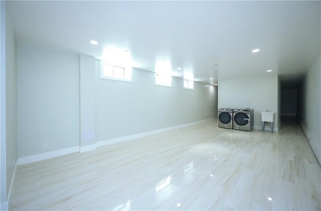 basement with recessed lighting, washing machine and dryer, baseboards, and a sink