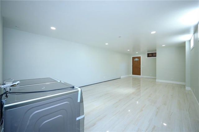 clothes washing area with baseboards, light wood finished floors, laundry area, washer / clothes dryer, and recessed lighting