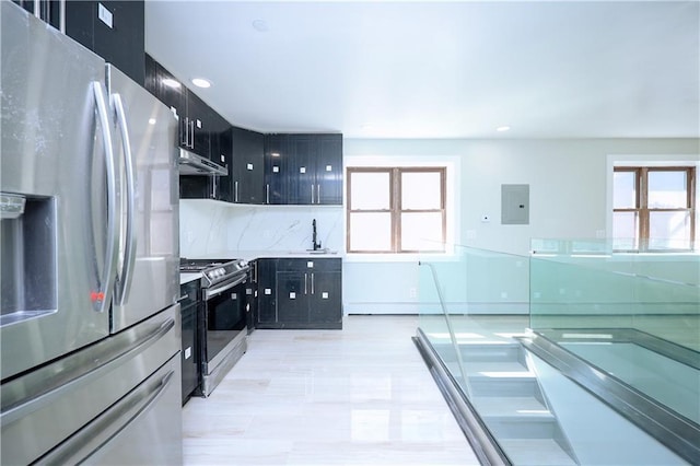 kitchen featuring backsplash, a healthy amount of sunlight, appliances with stainless steel finishes, and dark cabinets