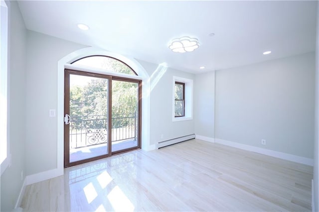 spare room with recessed lighting, a baseboard radiator, baseboards, and light wood-type flooring