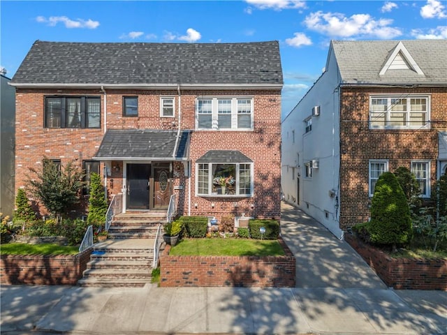 view of front of home featuring brick siding and a shingled roof