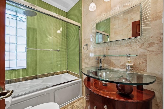 full bathroom with tile walls, vanity, shower / bath combination with glass door, and toilet