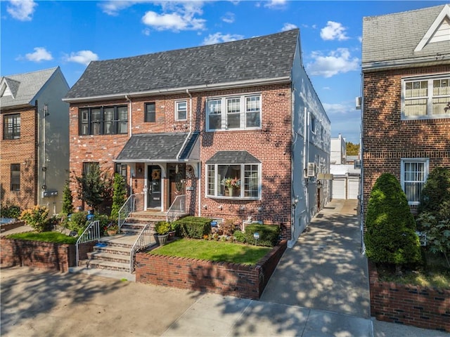 view of front of house featuring brick siding, roof with shingles, and a gate