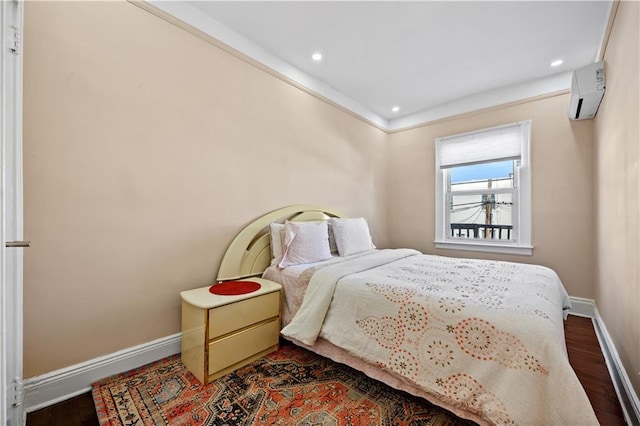 bedroom with dark wood-type flooring and a wall unit AC