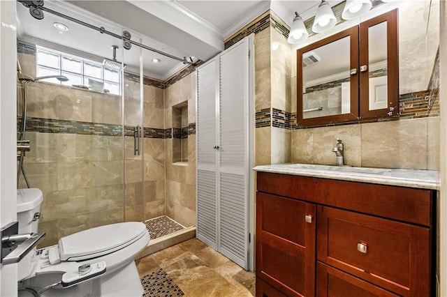 bathroom featuring tile walls, toilet, ornamental molding, vanity, and an enclosed shower