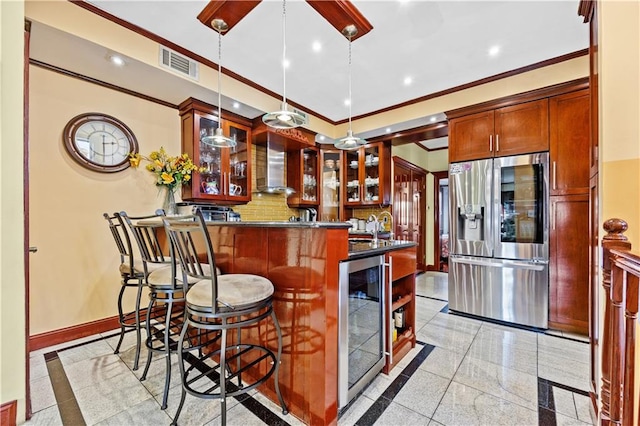 kitchen with wine cooler, stainless steel fridge with ice dispenser, ornamental molding, wall chimney exhaust hood, and decorative light fixtures