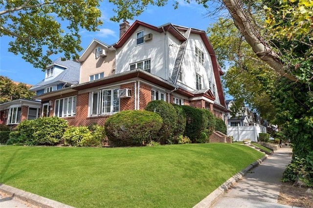 7523 Narrows Ave, Brooklyn, NY 11209 - view of side of home with brick siding, a chimney, a lawn, stucco siding, and a wall mounted AC