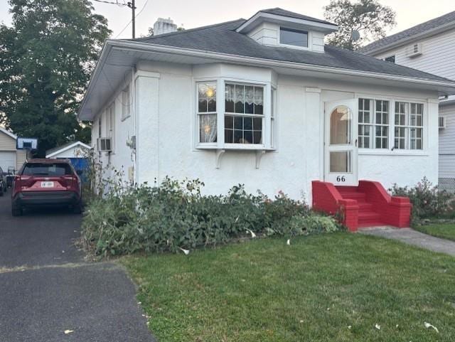 bungalow-style house with a front lawn