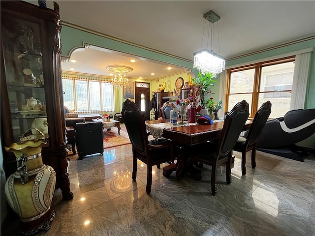 dining area featuring ornamental molding, a healthy amount of sunlight, and a notable chandelier