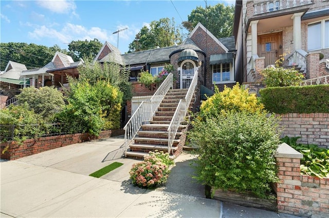 view of front of property featuring stairs and brick siding