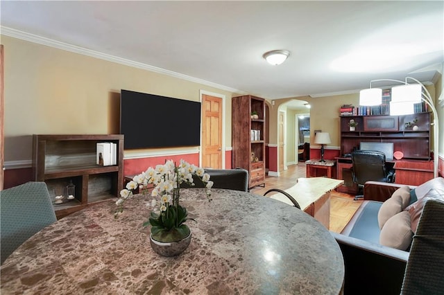 dining area featuring arched walkways and crown molding