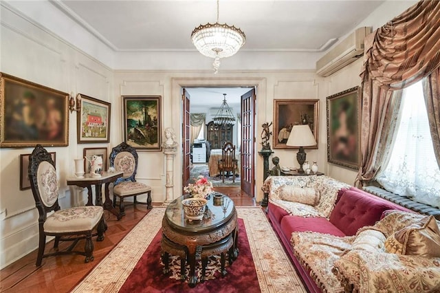 sitting room with an AC wall unit, parquet floors, and a chandelier