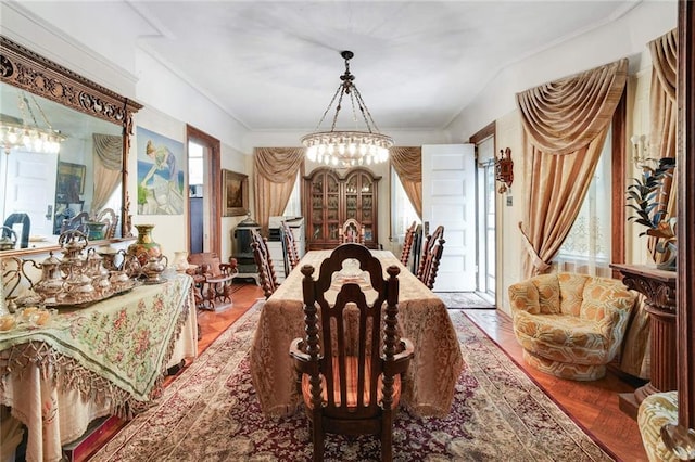 dining space with parquet floors, crown molding, and a chandelier