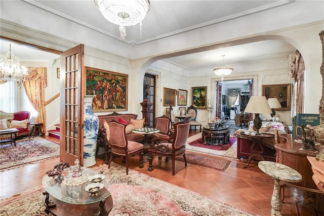 sitting room featuring crown molding, french doors, and a notable chandelier