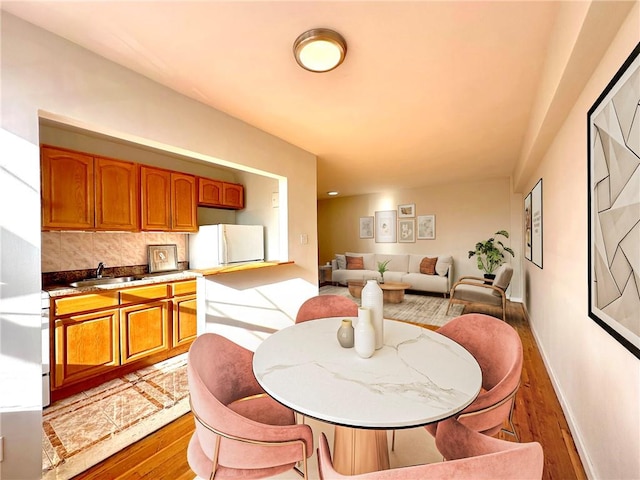 dining room with light wood-style floors and baseboards