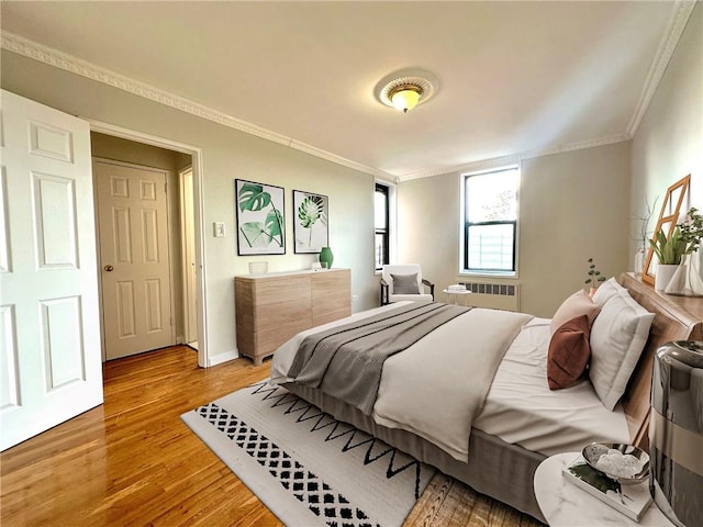 bedroom with ornamental molding, radiator, and hardwood / wood-style floors